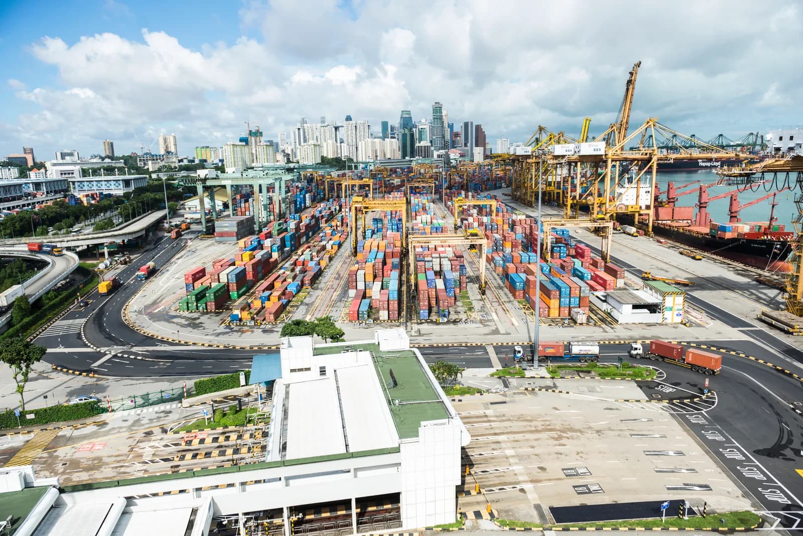 The Port of Singapore in daylight, container terminal and downtown skyline beyond
