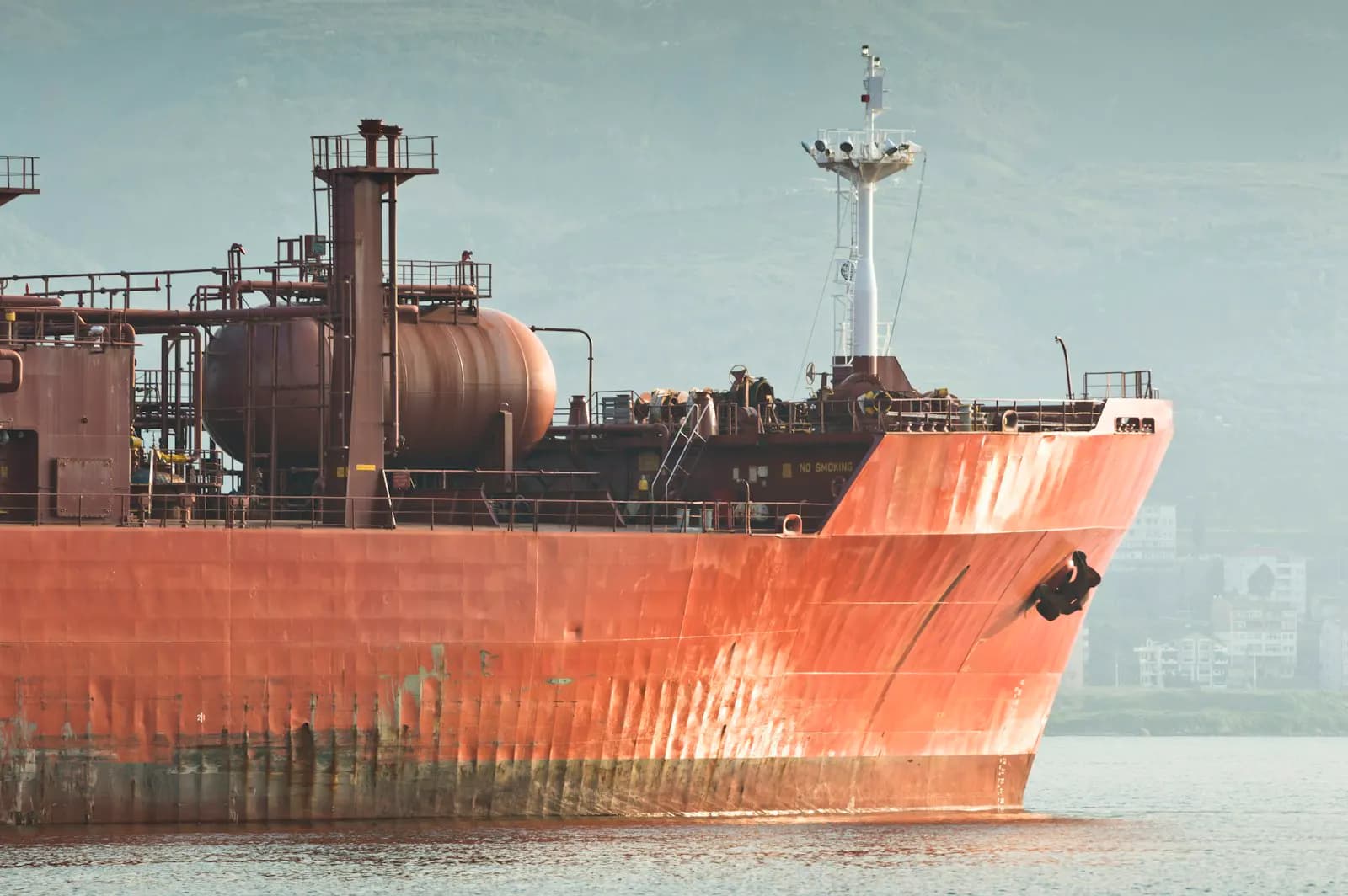 A weathered cargo ship hull at anchor