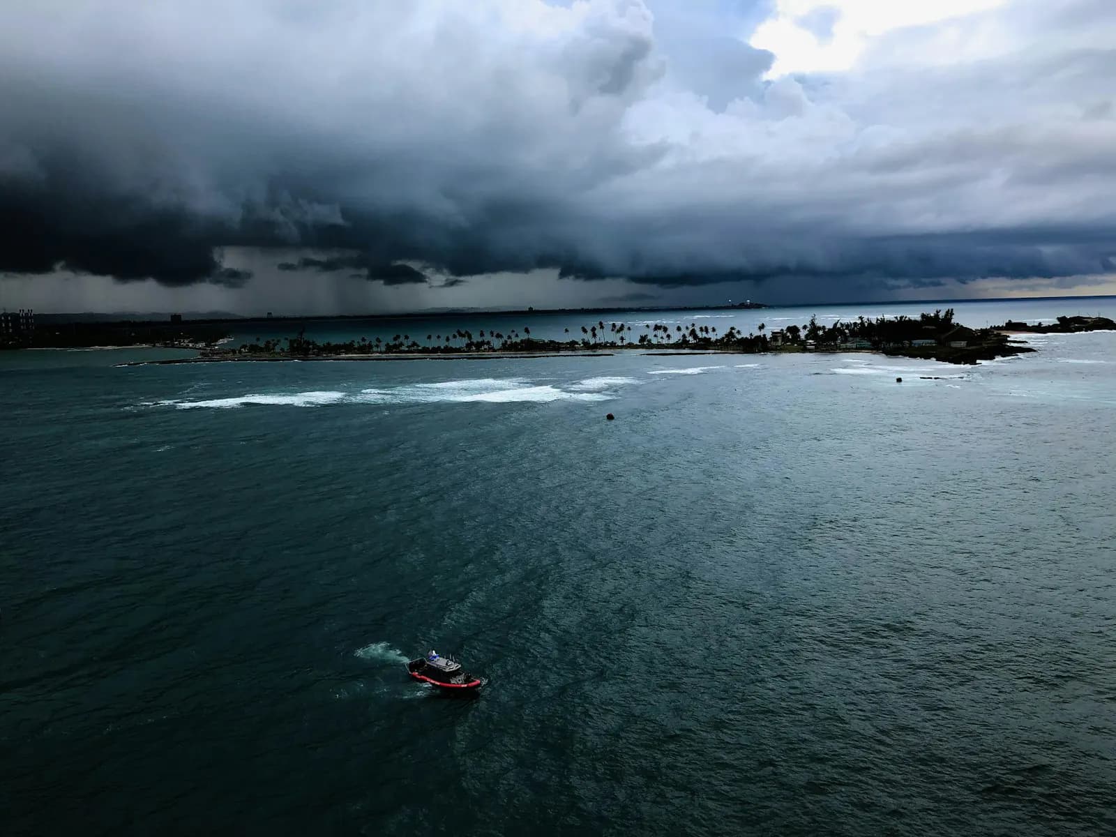 A small boat crossing open water under stormy skies