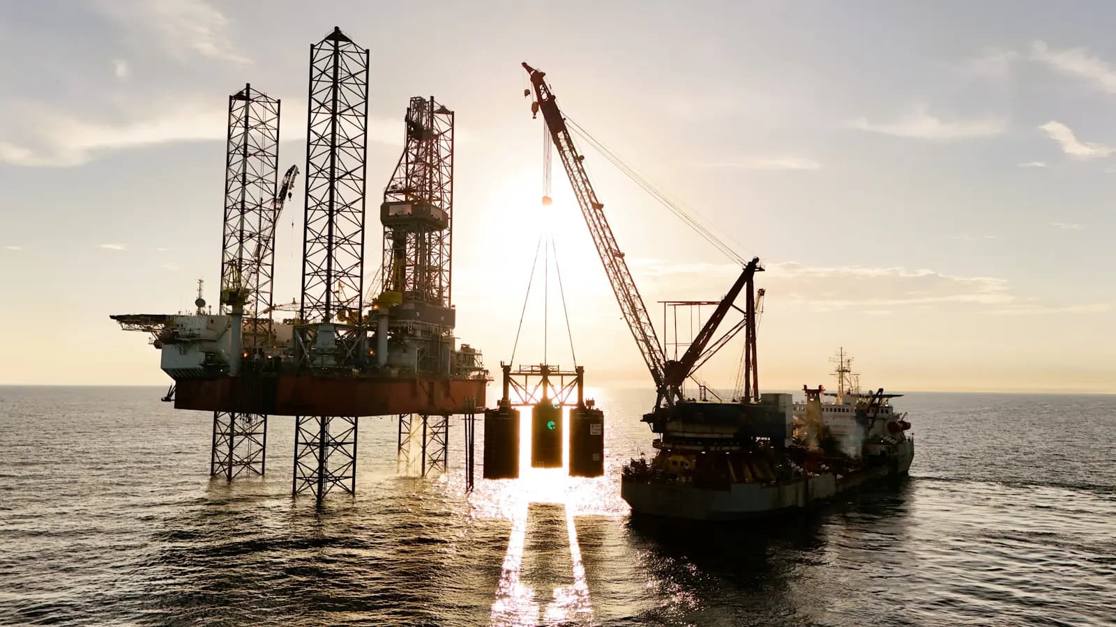 An offshore construction vessel with a crane working near a platform