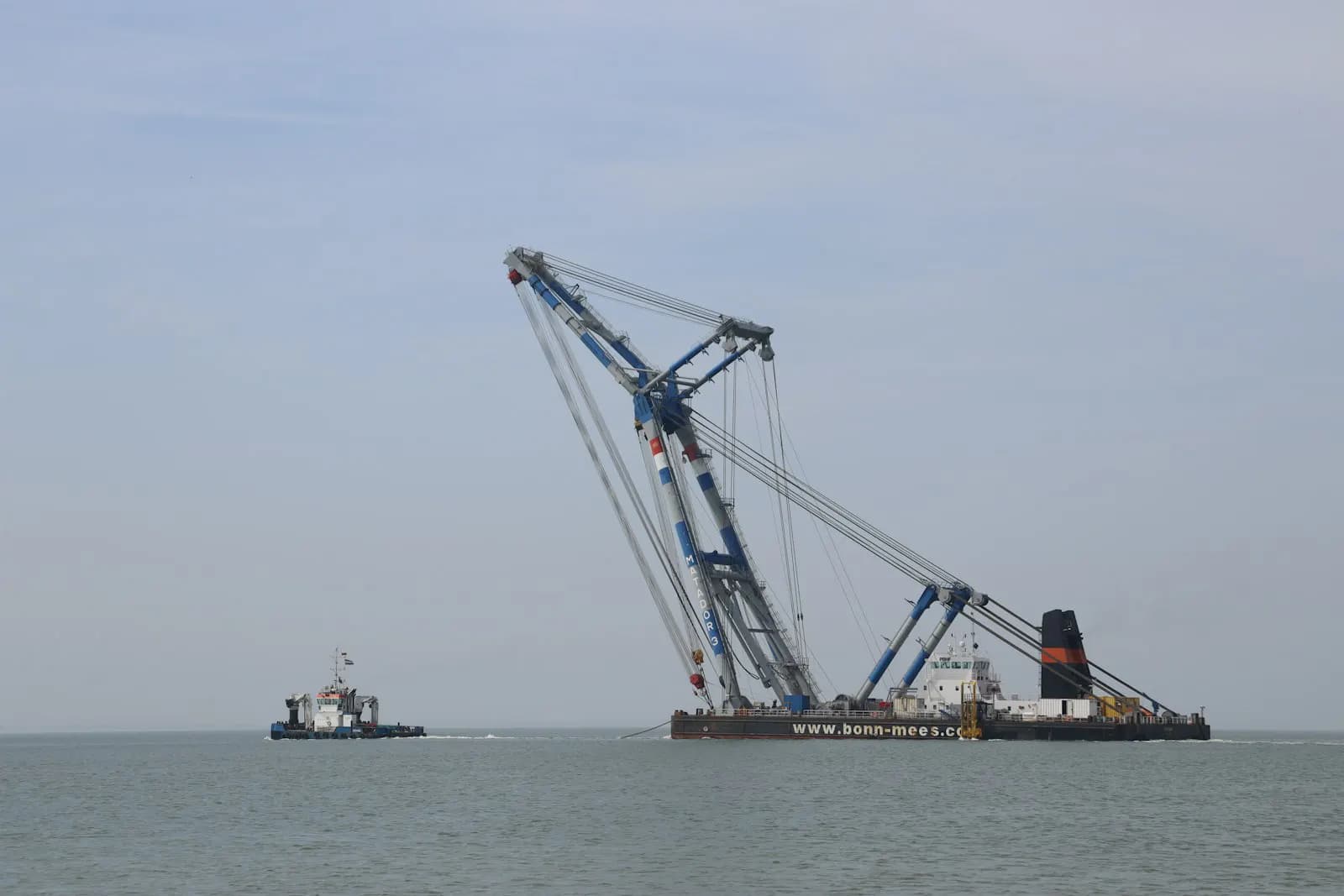 A large offshore support vessel with a crane at sea