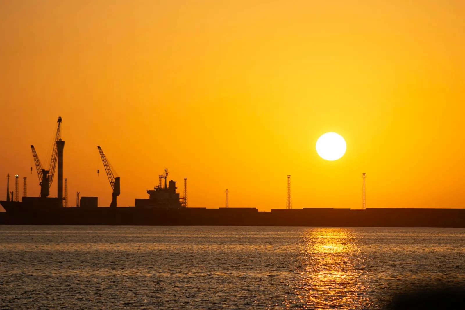 A container ship transiting open water at dusk