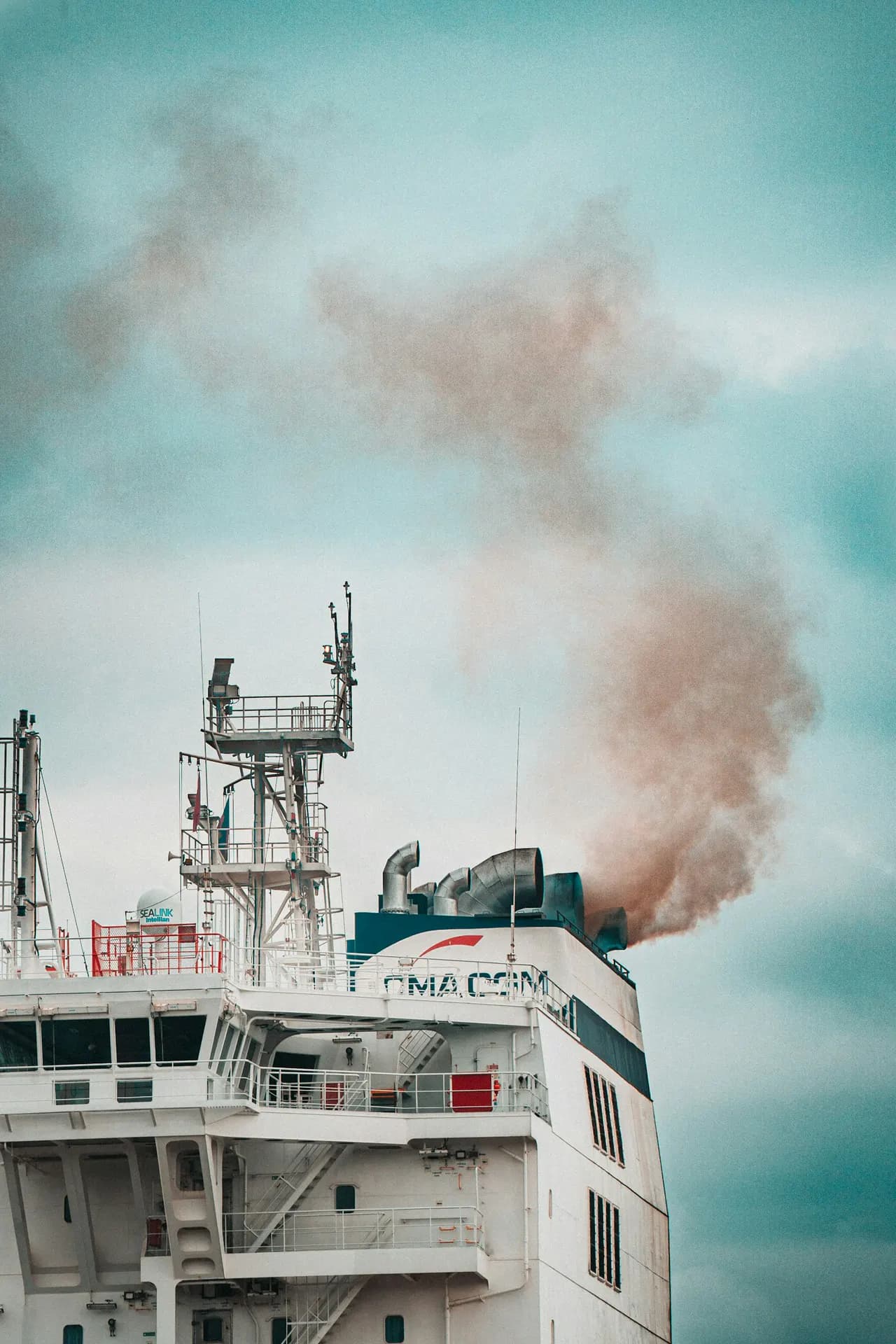 A container ship's exhaust stack against a clear sky