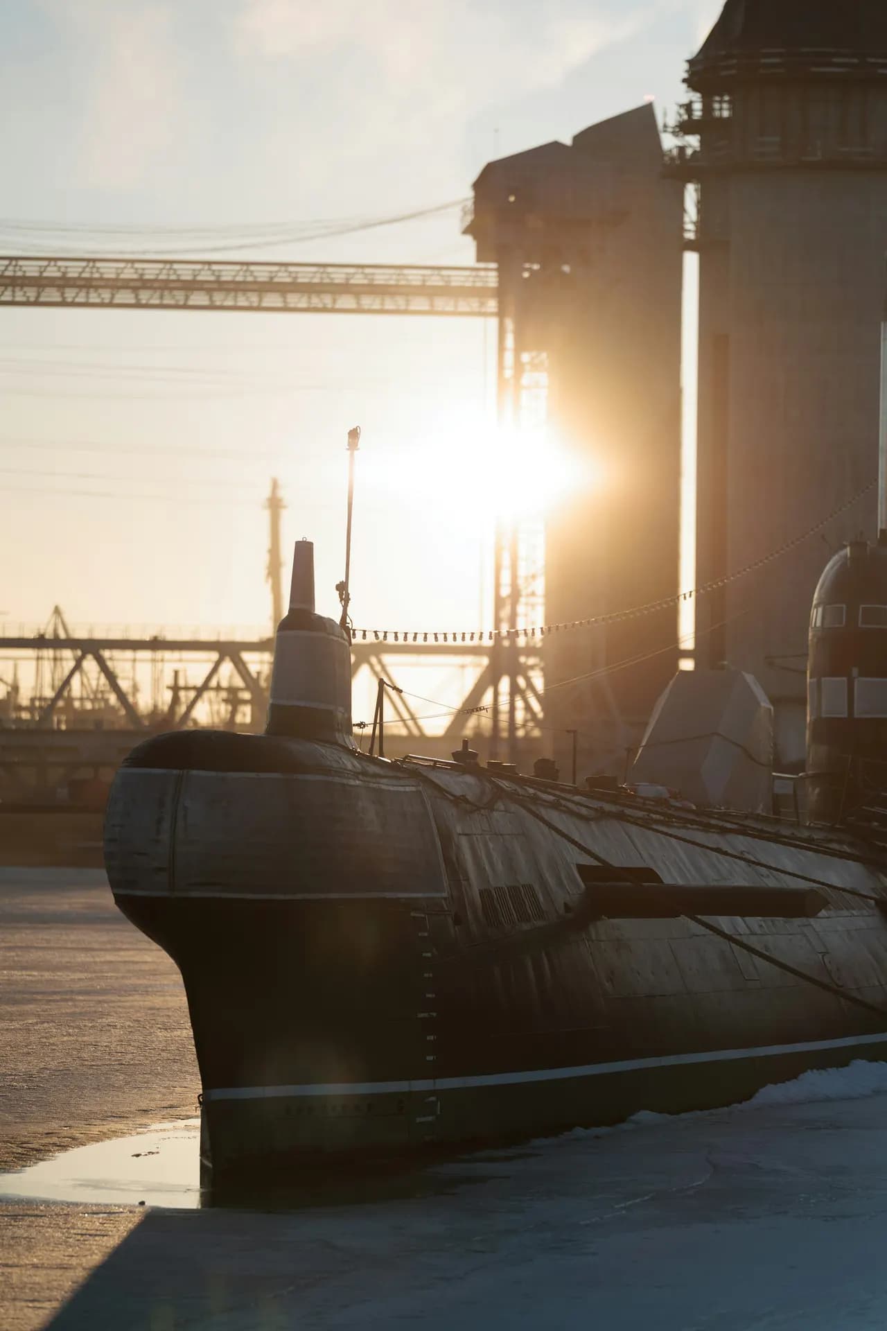 A naval submarine docked at a maintenance facility