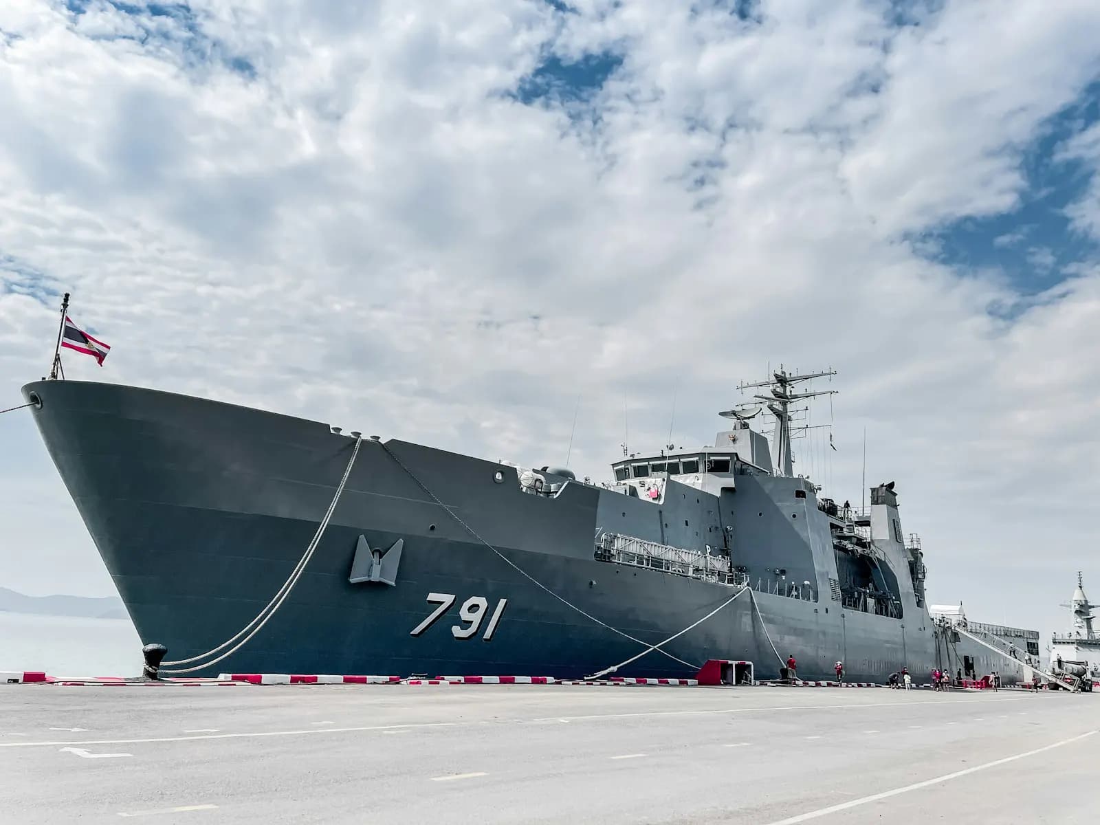 A naval combat vessel at a shipyard launch ceremony