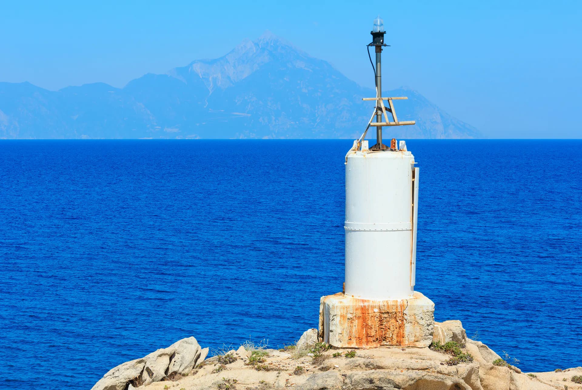 A rocky shoreline with a navigation beacon on an exposed stretch of coast