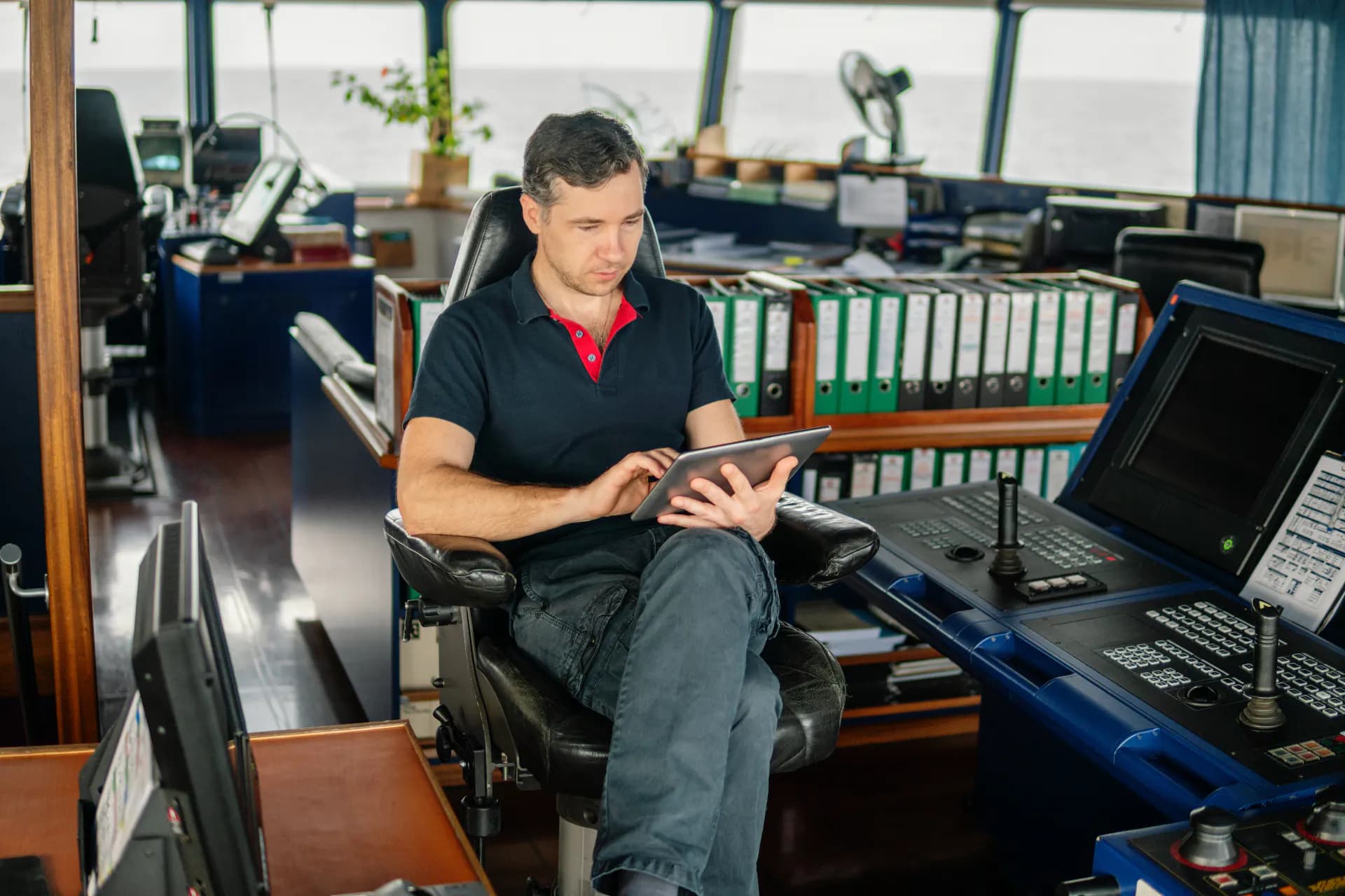 Officer monitoring navigation displays on a ship's bridge