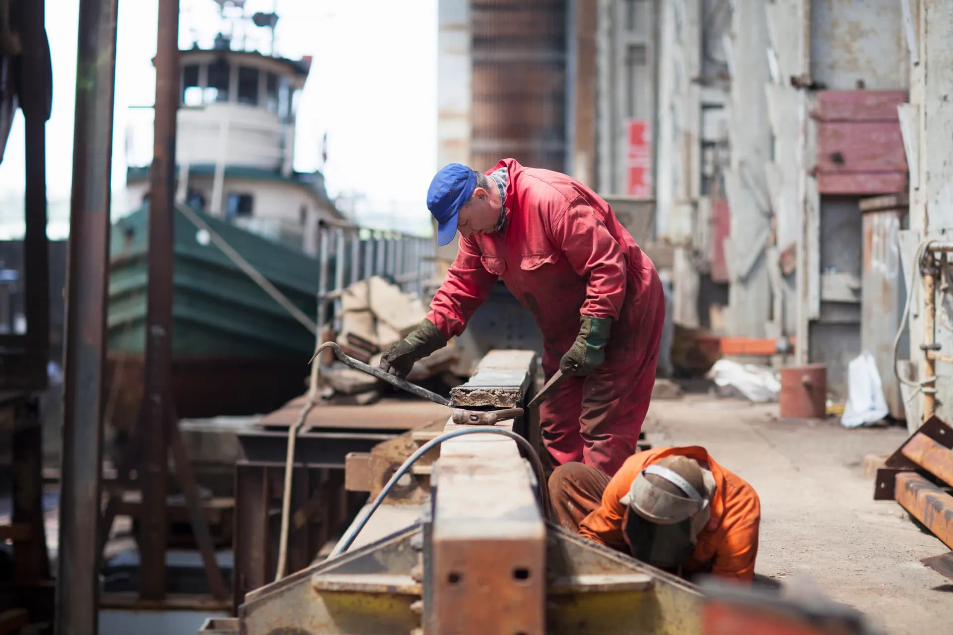 Workers repairing a vessel in a shipyard, illustrating ship repair and conversion work