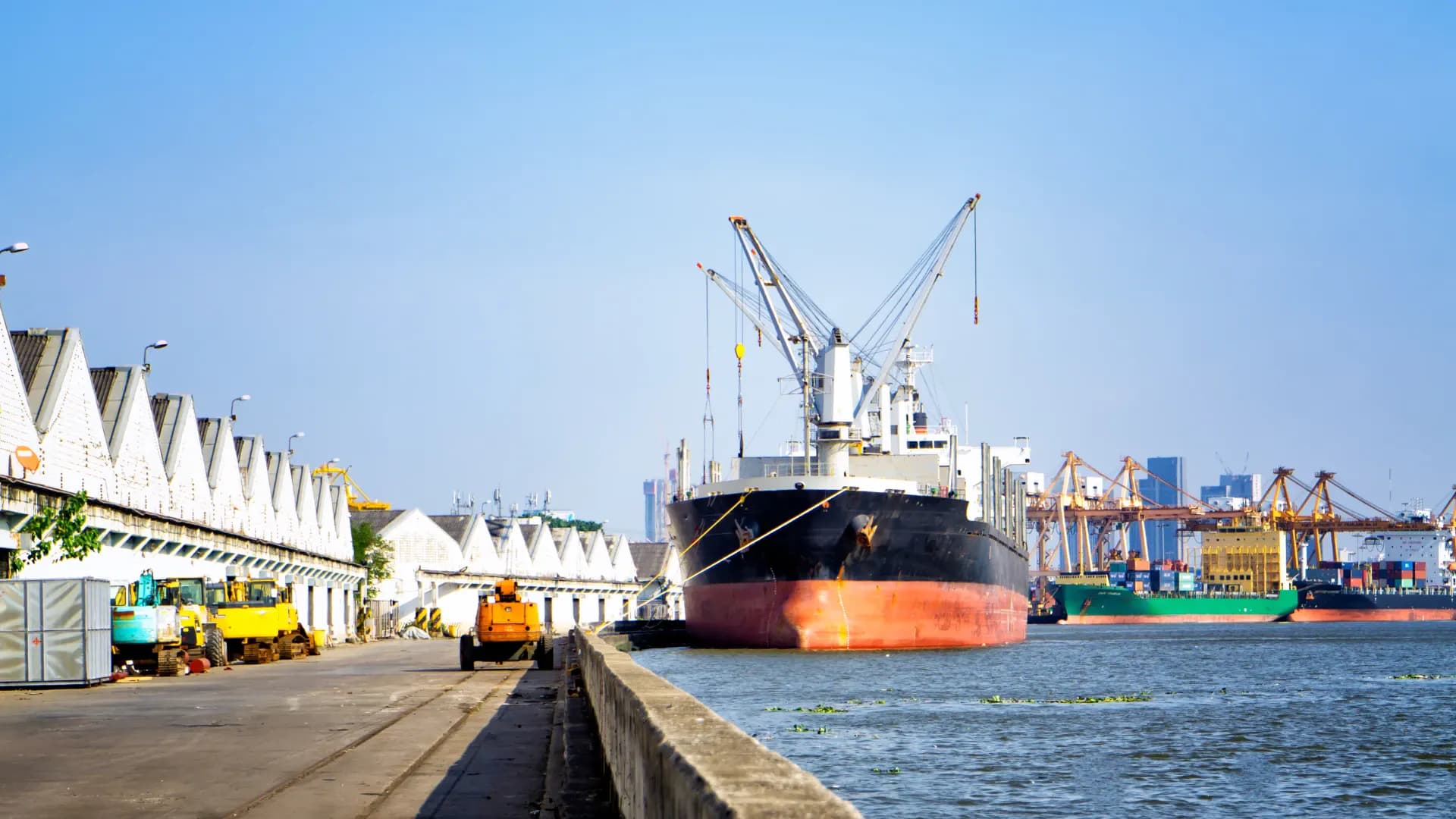 Container ship moored at a harbour berth under a clear sky