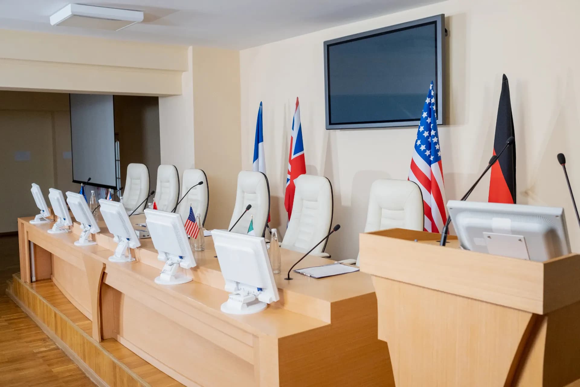An empty conference room set with national flags and microphones