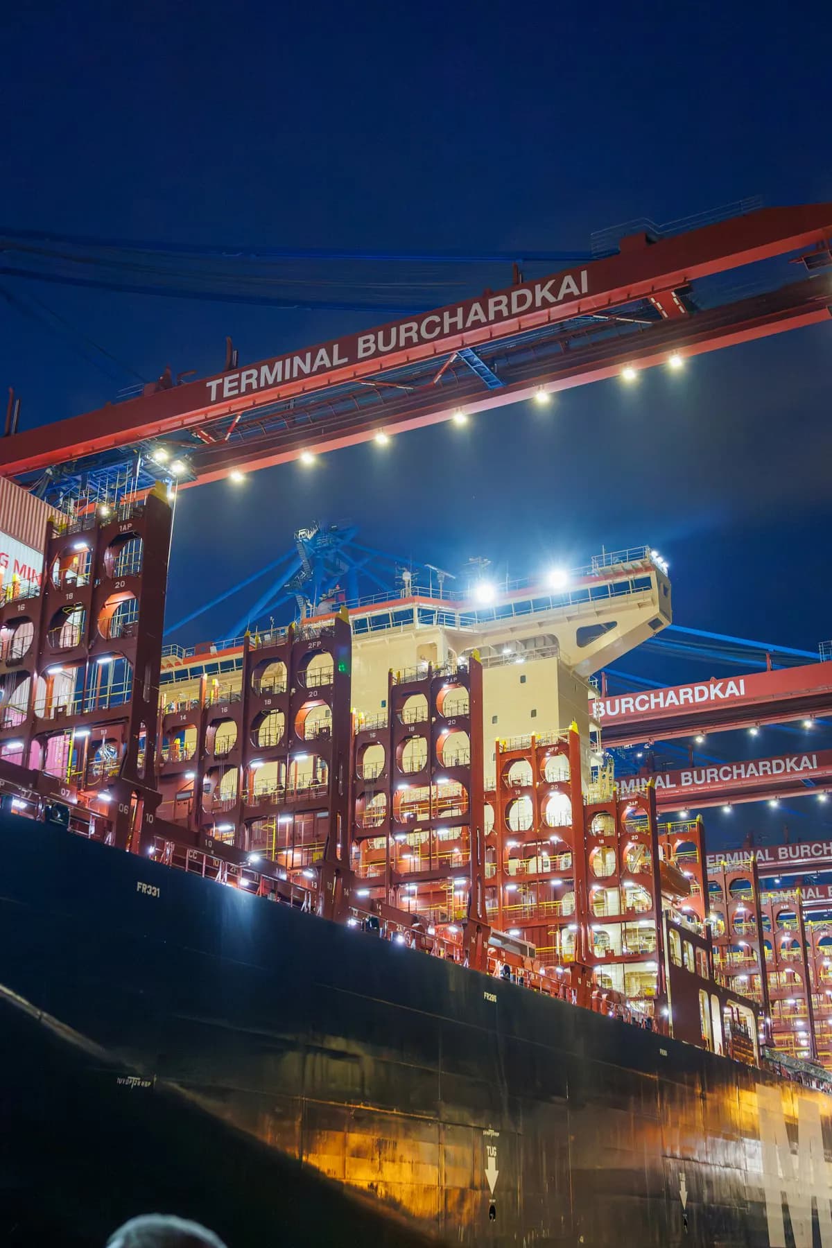 Container ship being loaded at a port at night