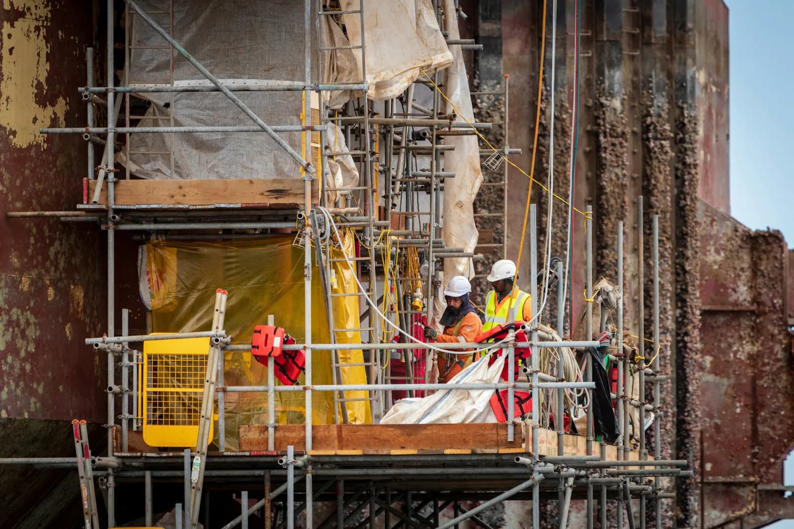 Industrial workers on scaffolding at an energy facility