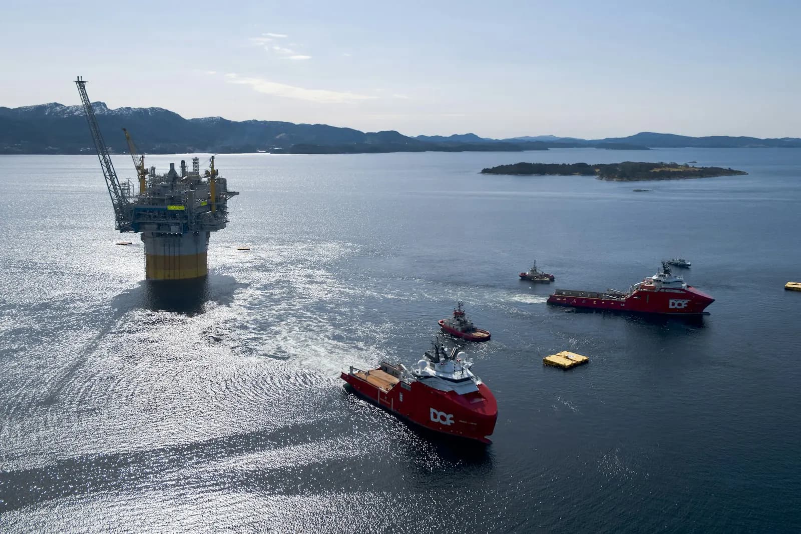 Offshore rig under tow by support vessels