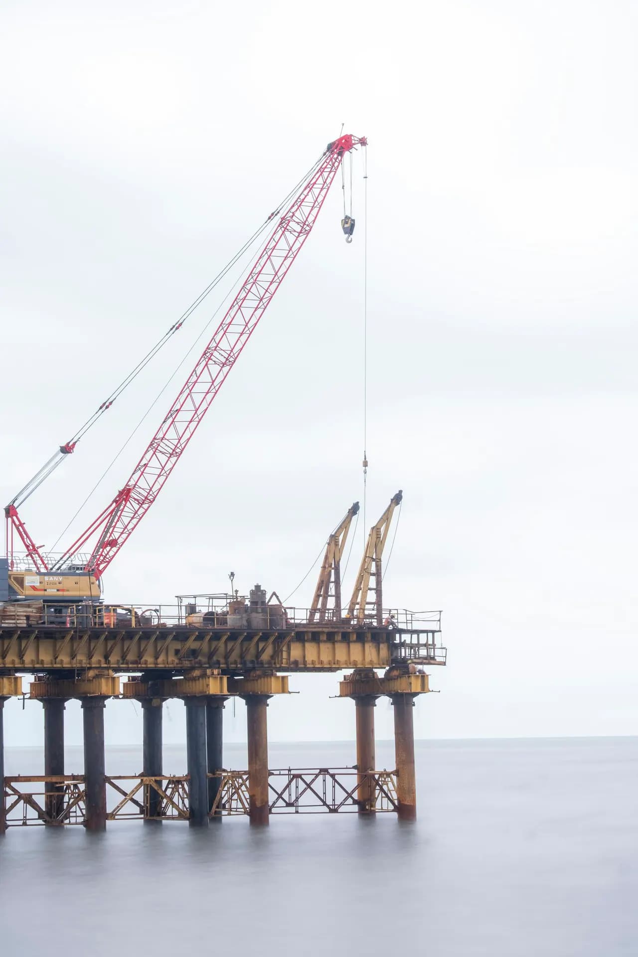 Crane on an offshore platform over calm water