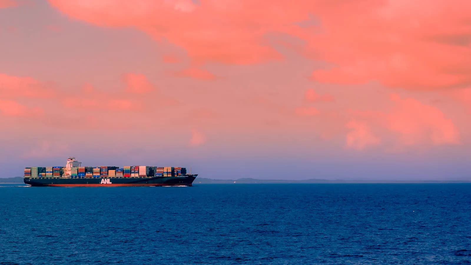 Cargo ship at sea under a cloudy sky