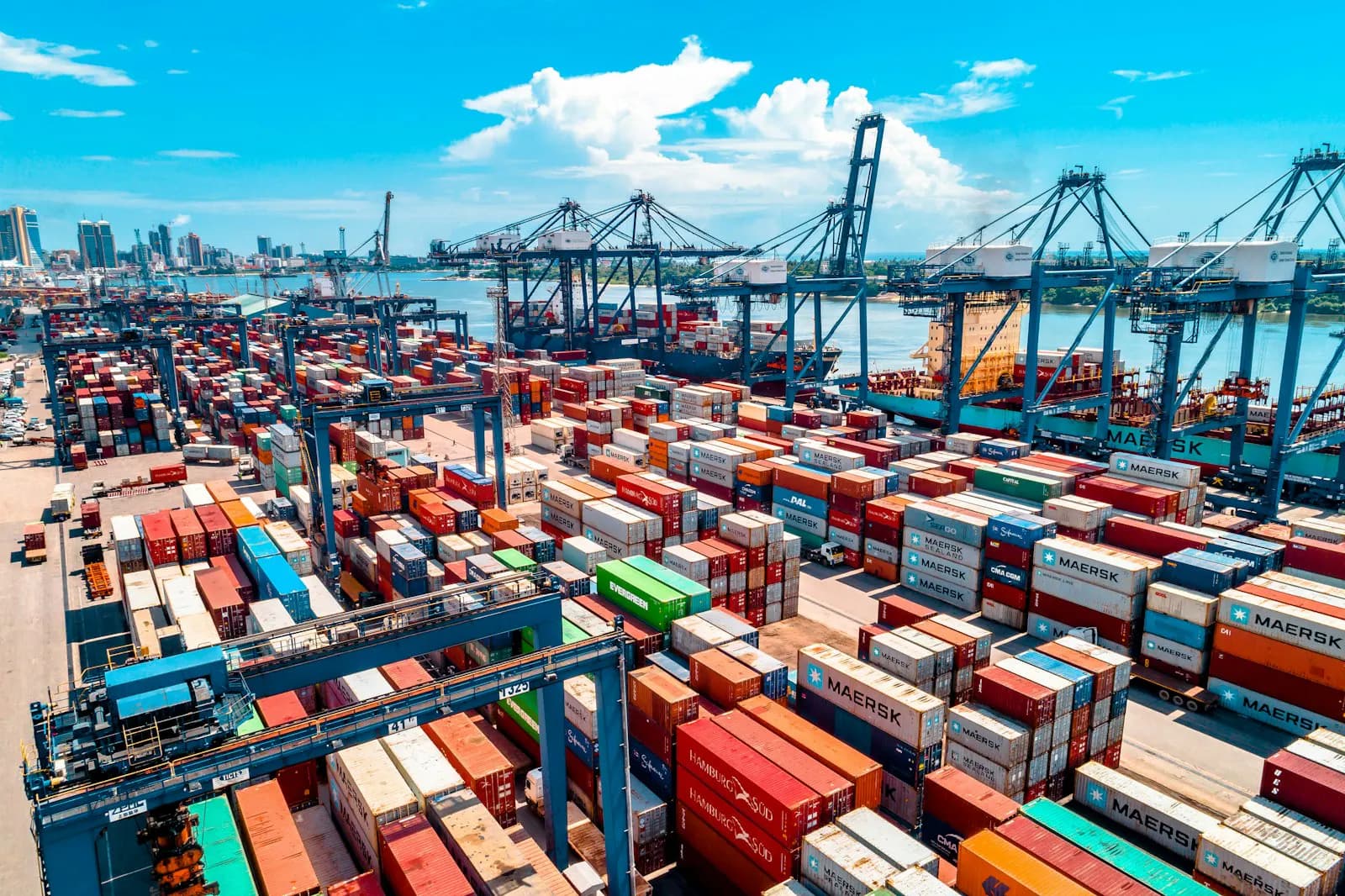 Container terminal with cranes and stacked containers at dusk
