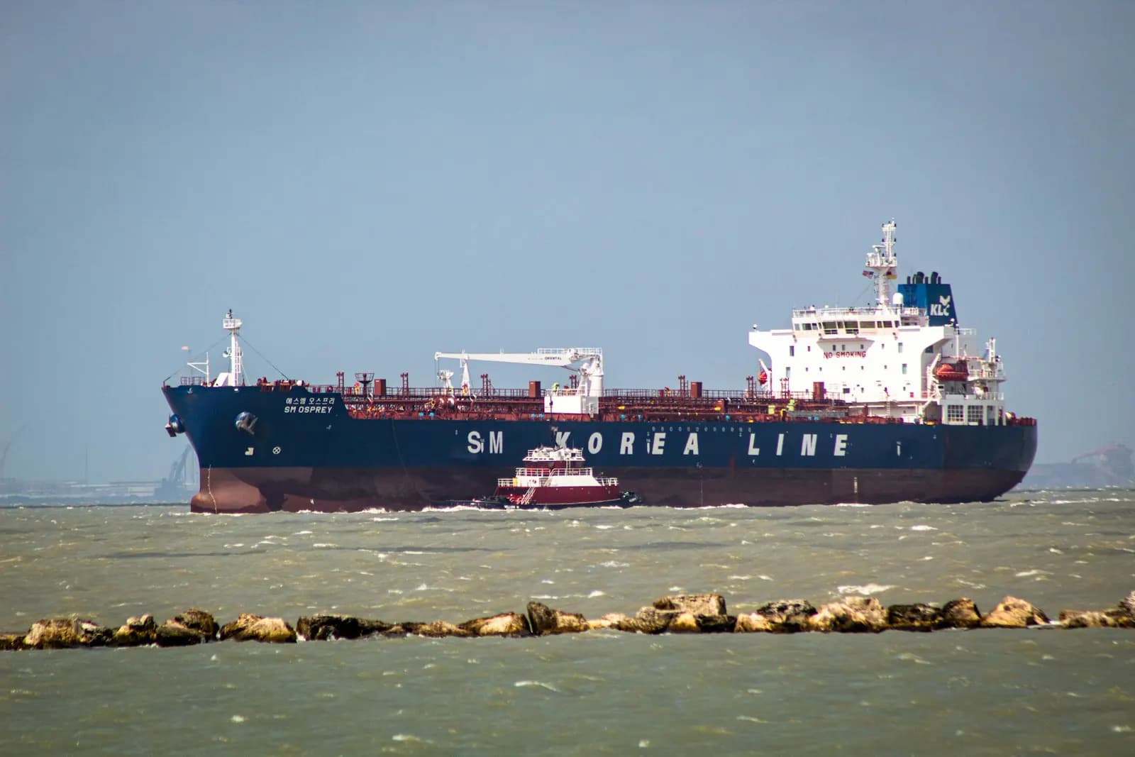 A container ship navigating a narrow port access channel