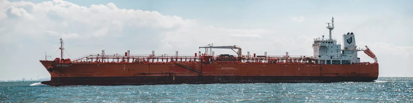 An oil tanker underway near a busy strait