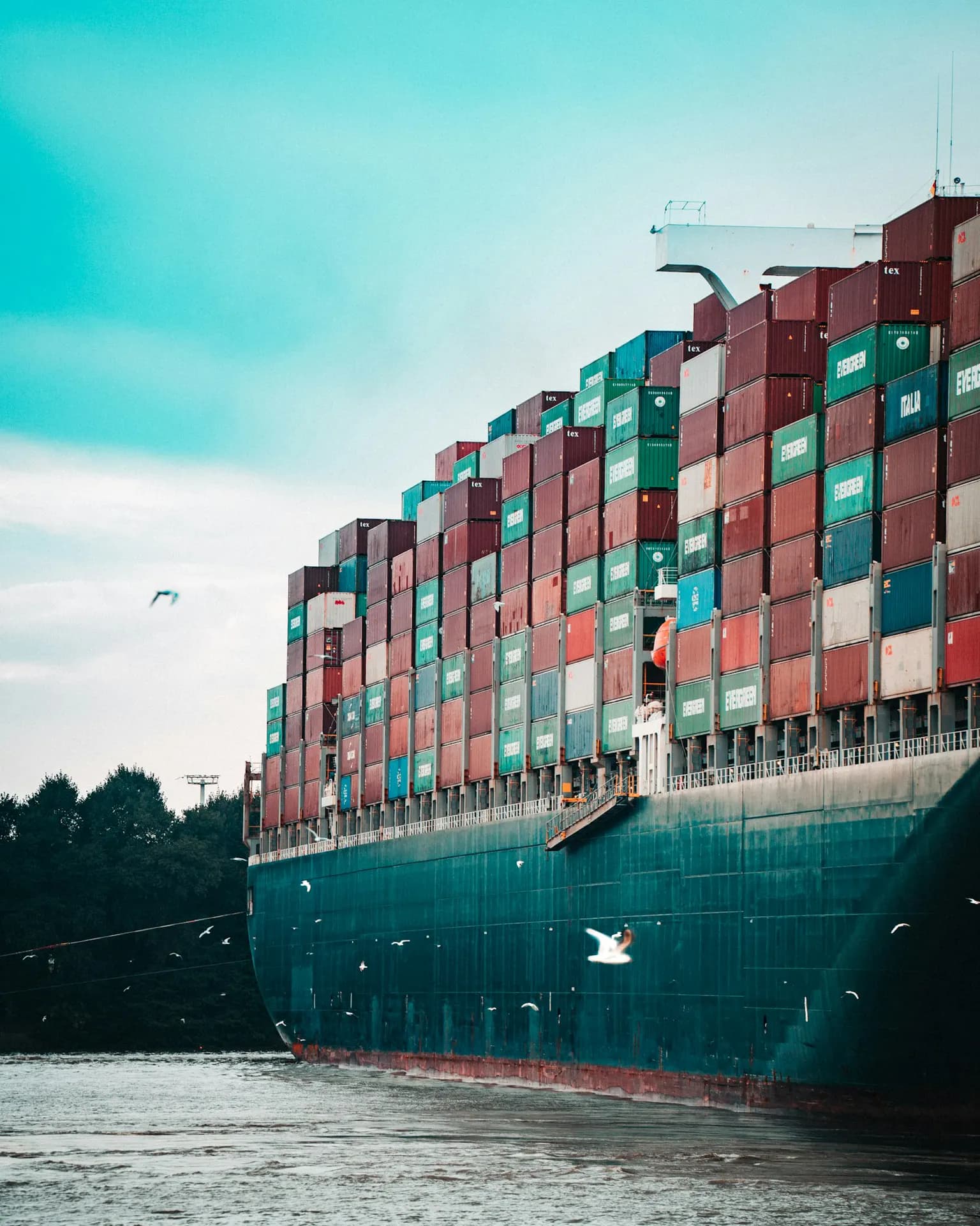 A container ship loaded with boxes departing a port
