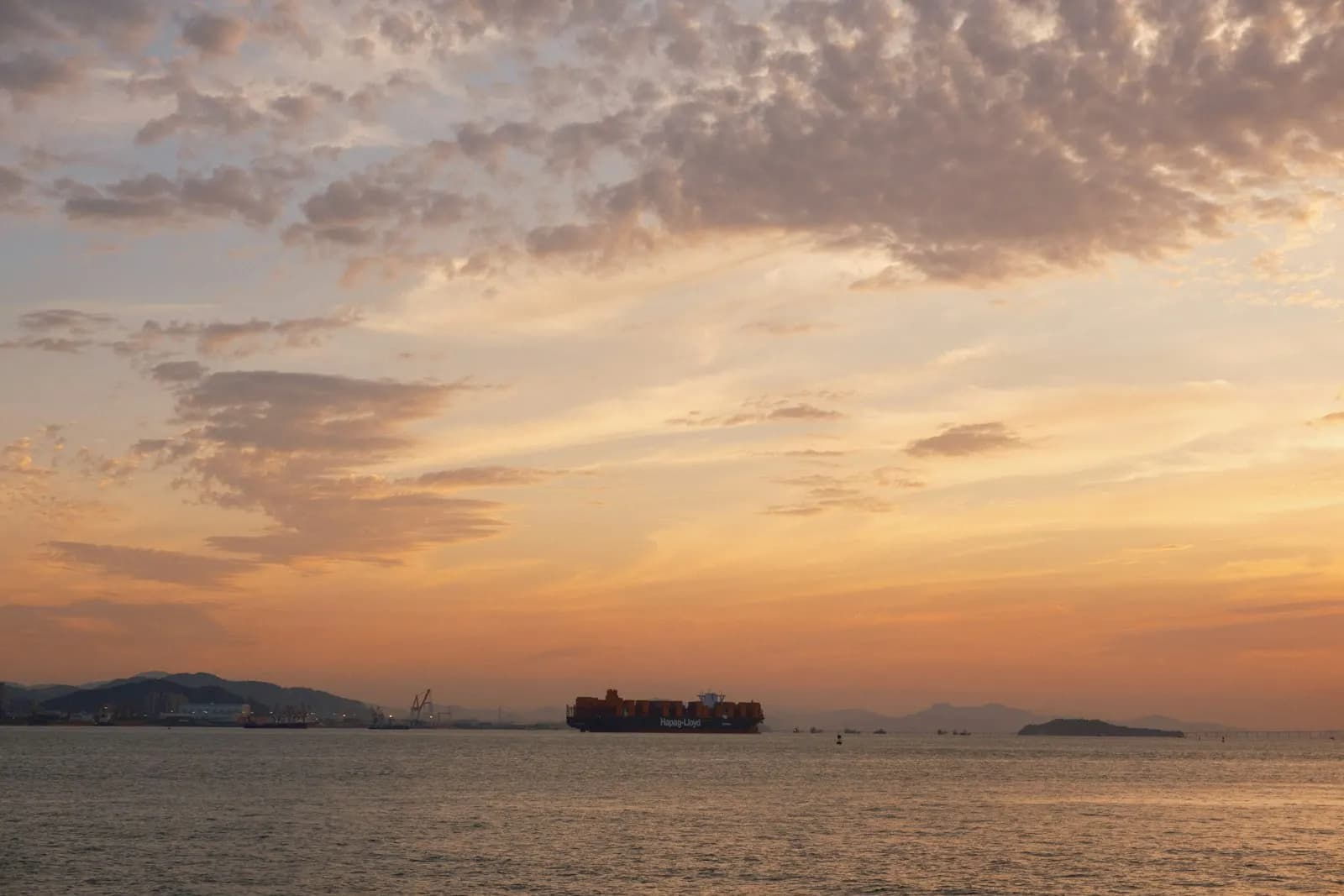 Container ship sailing on the ocean at sunset