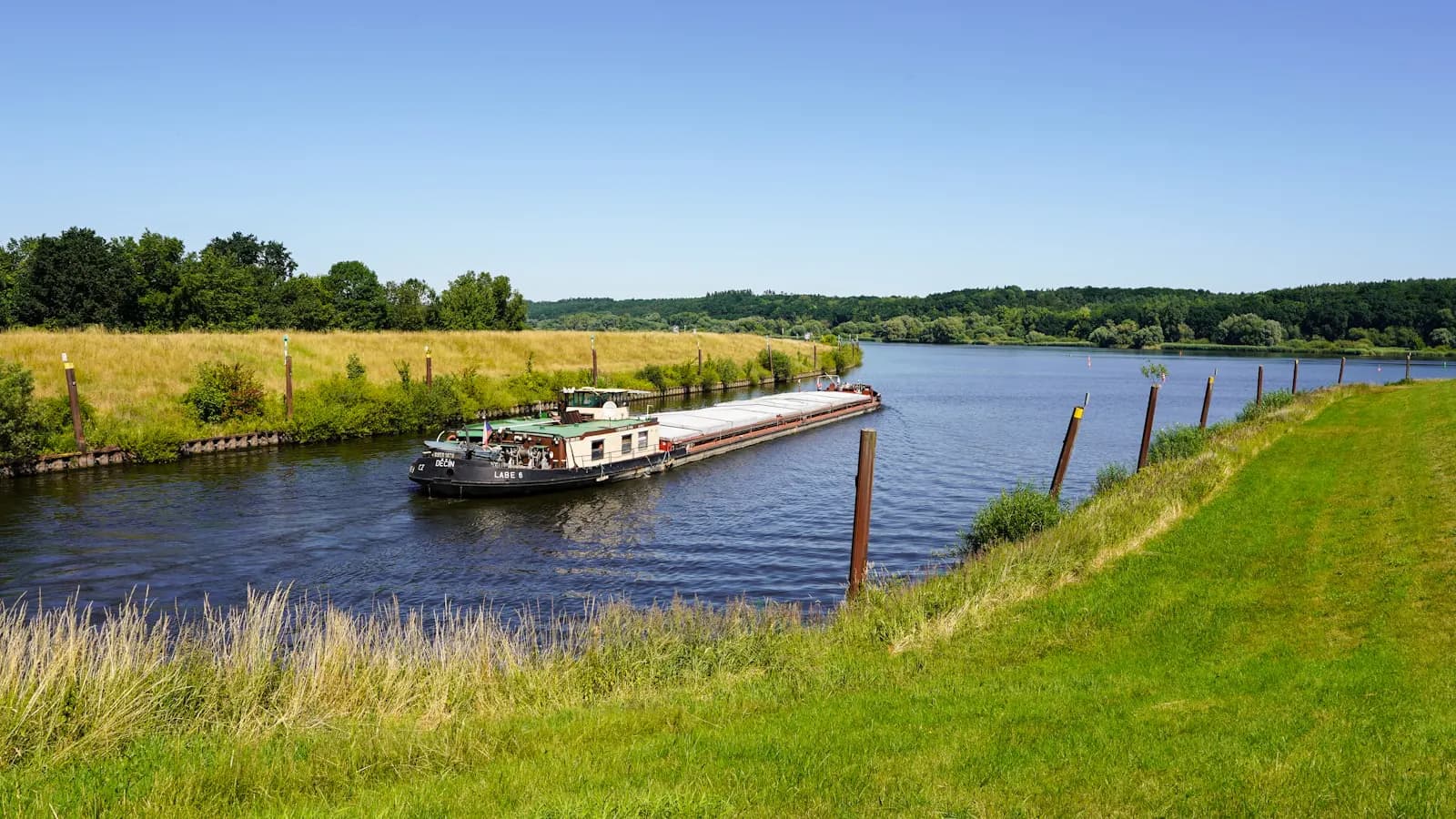 Barge travelling down a wide calm river