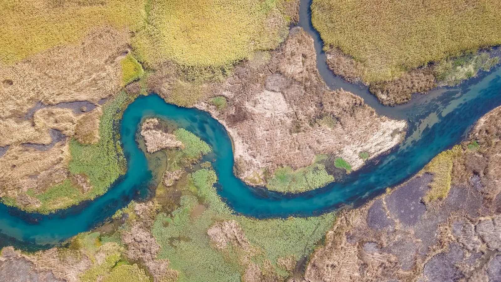 Aerial view of a winding river through dry terrain