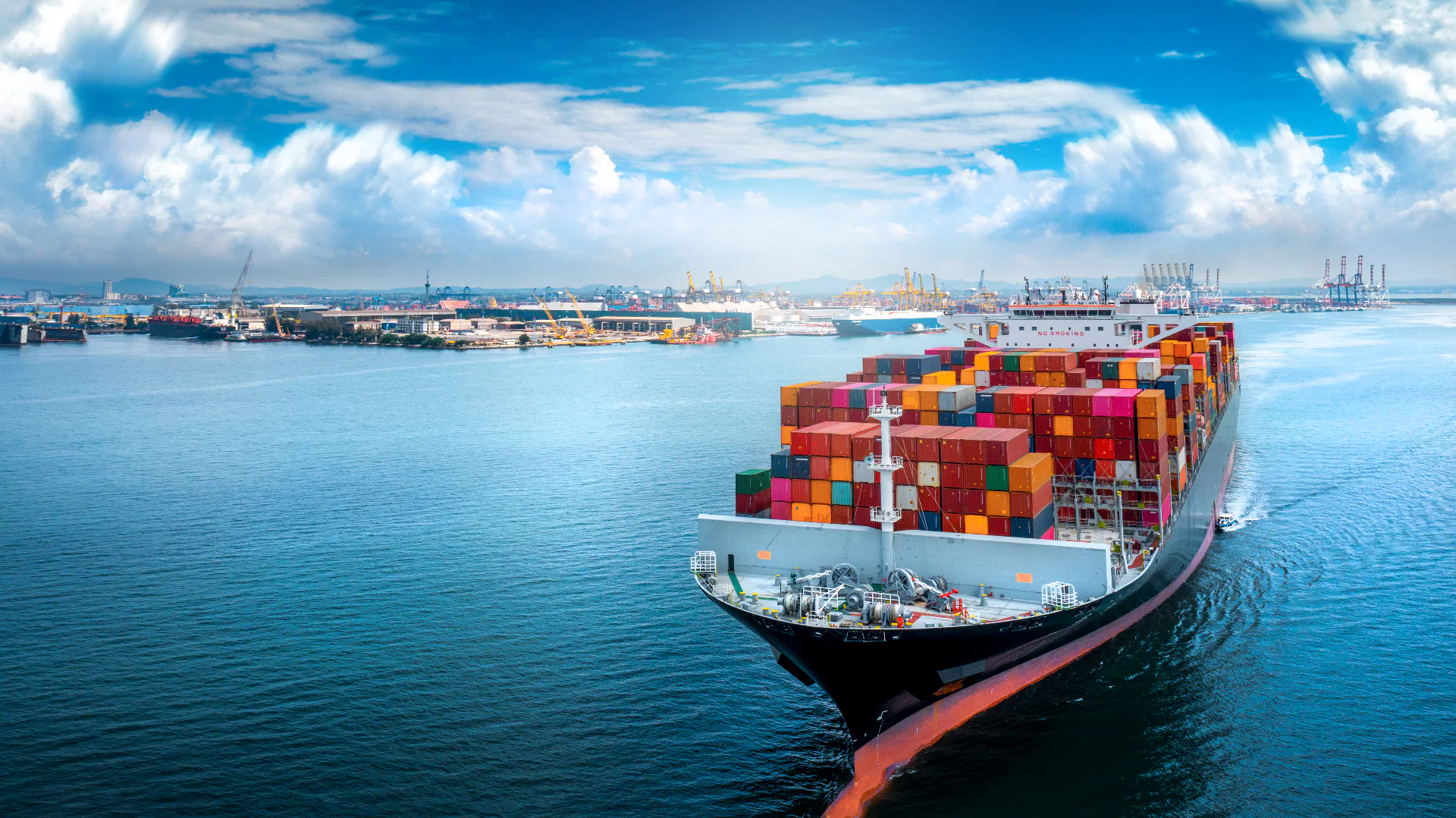Aerial side view of cargo ship carrying container