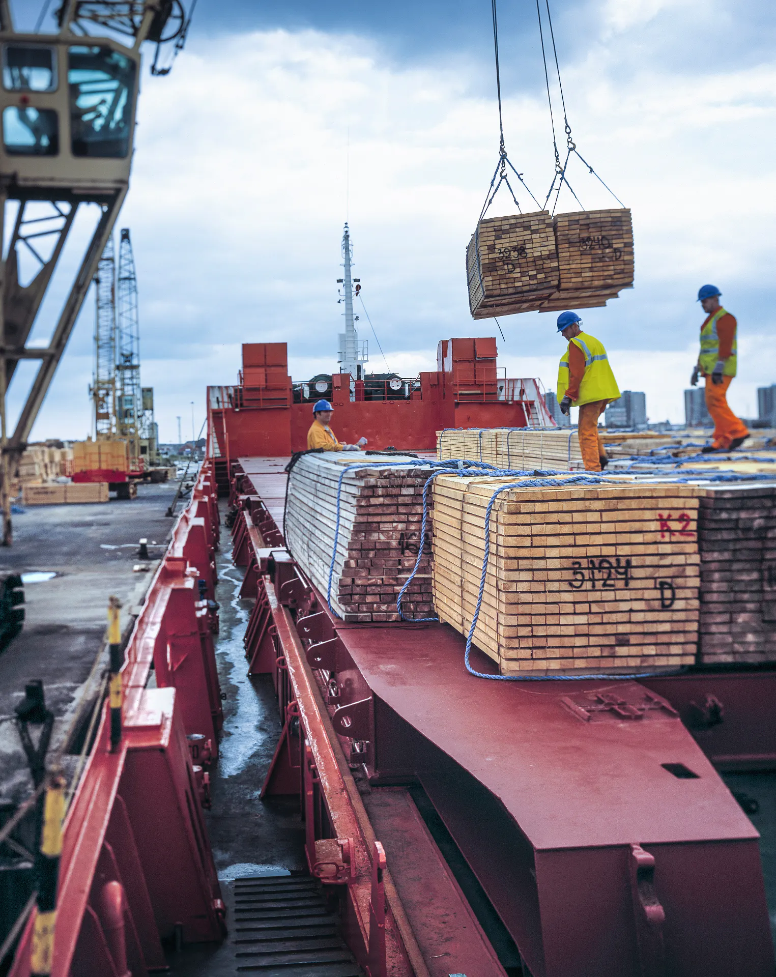 Dock workers handling cargo alongside a ship