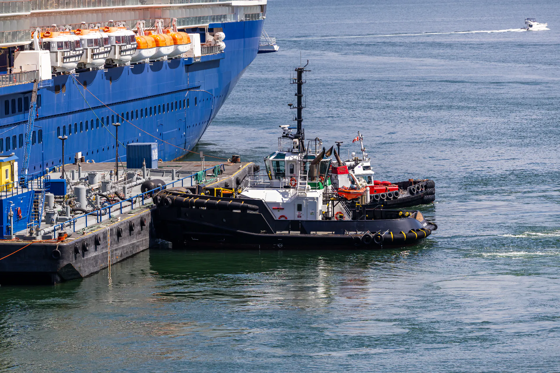 Harbour tugs working alongside a larger vessel