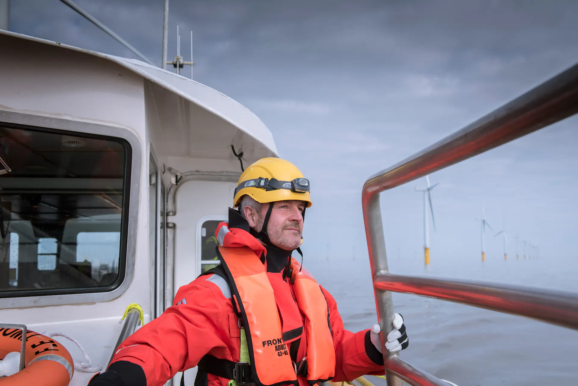 Man stands on boat at wind farm