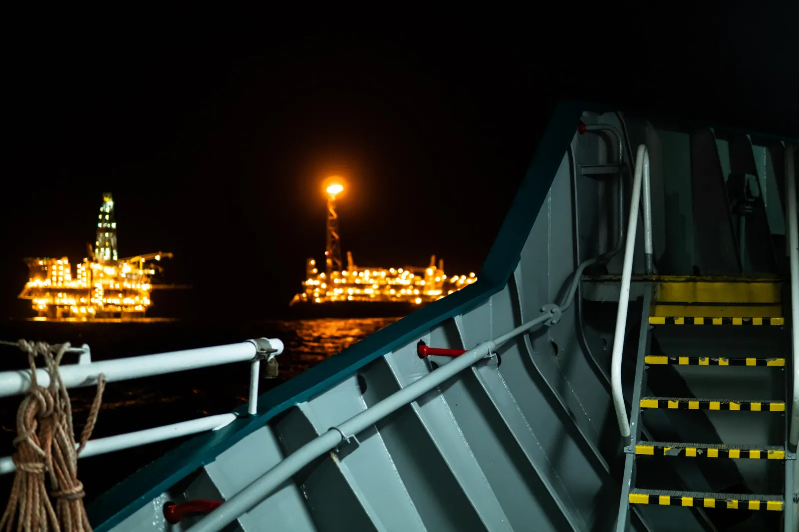Offshore drilling rigs lit up at night