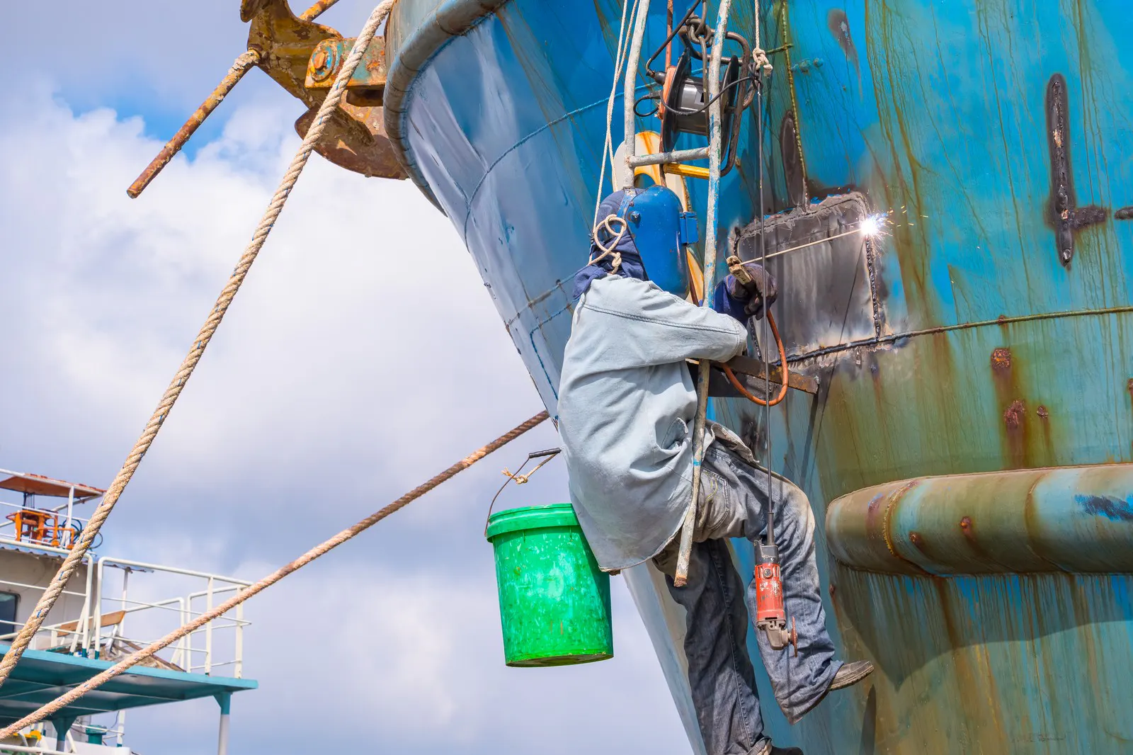 Shipyard worker on the hull of a vessel under construction