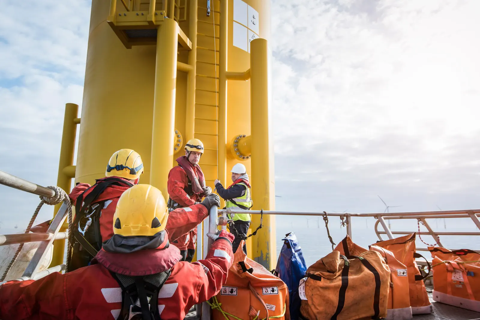 Offshore technicians preparing to climb a wind turbine