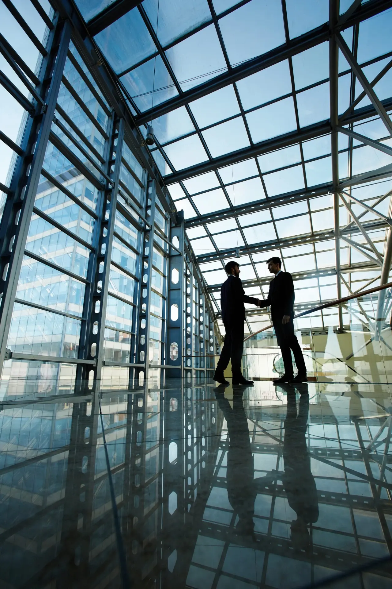 Two professionals meeting in a glass office building