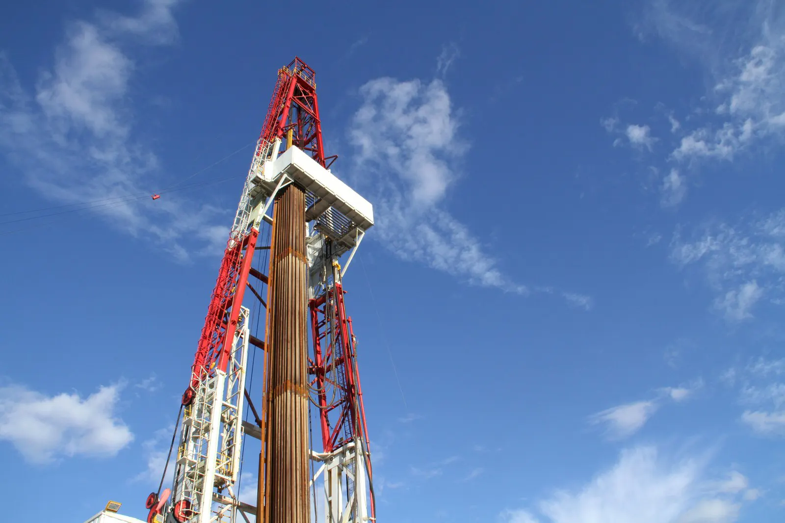 A drilling derrick against a blue sky