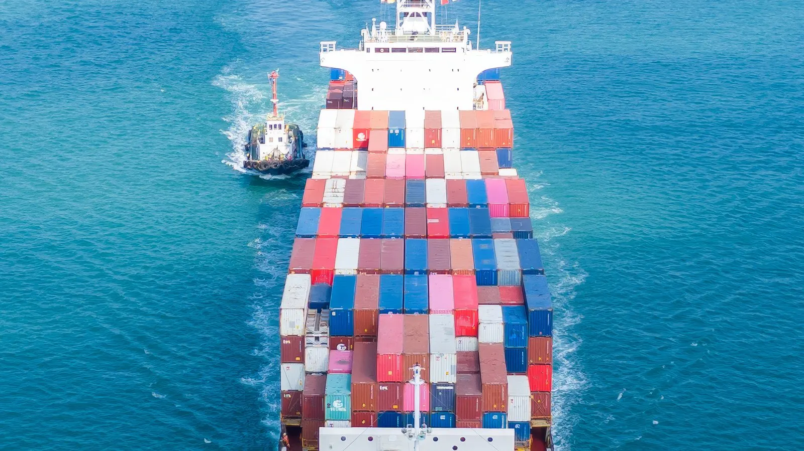 Container ship under way with a small craft alongside