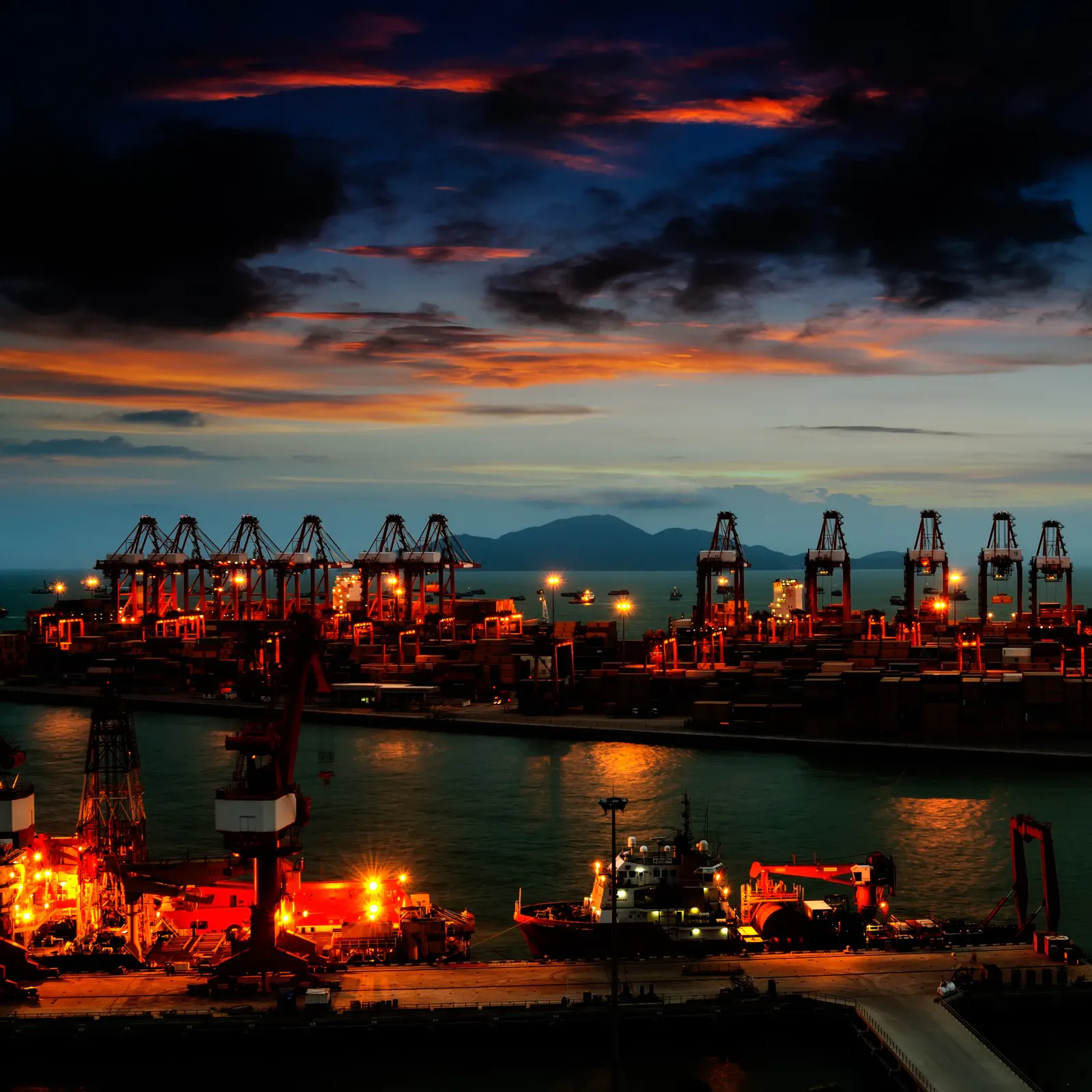 Port terminal illuminated at night under a dark sky