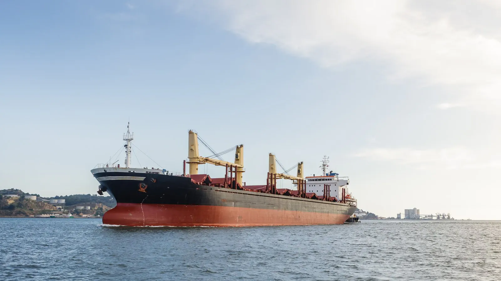 Cargo ship close to a shoreline in shallow water