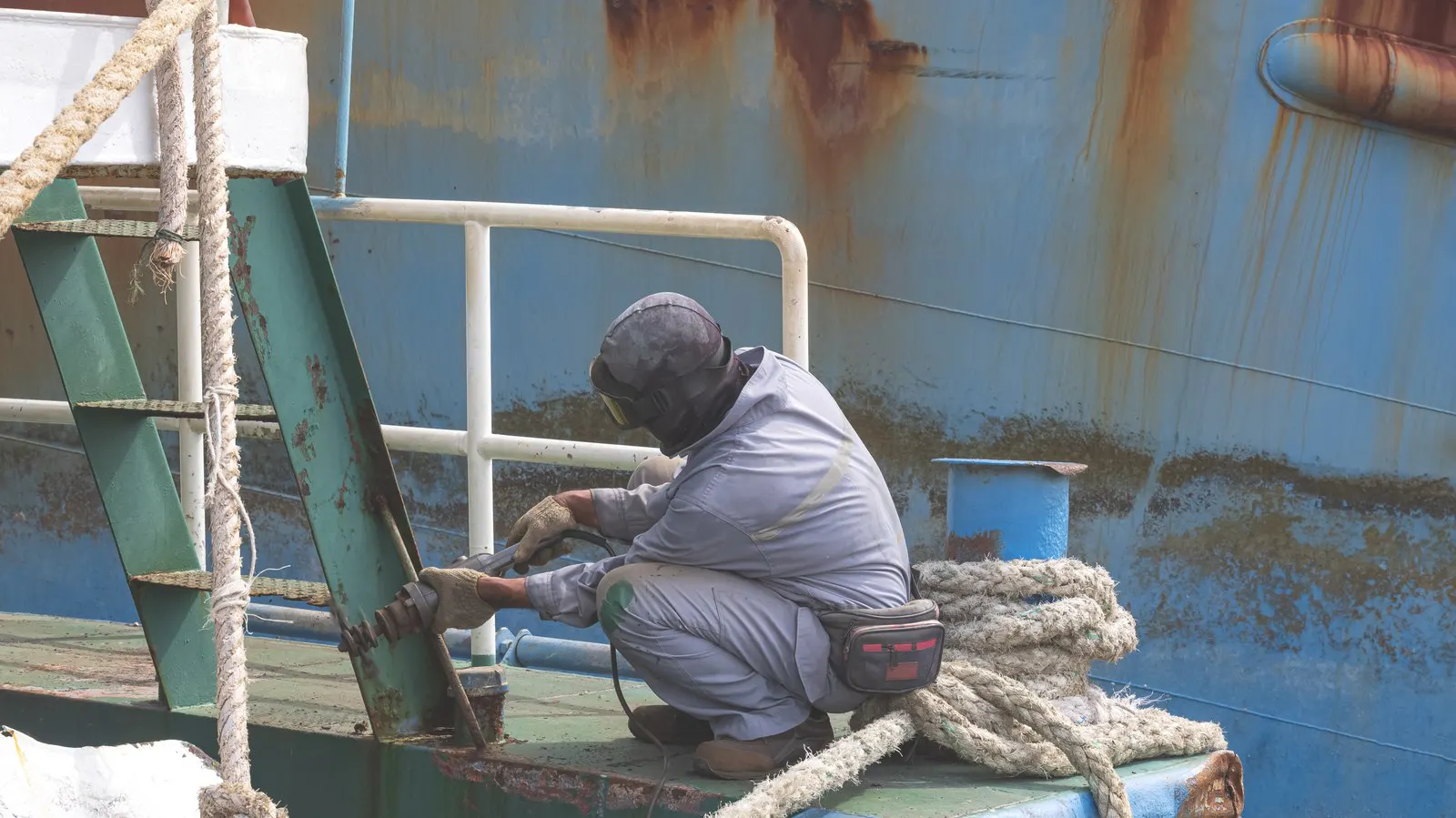 Worker cutting steel on the hull of a vessel being dismantled
