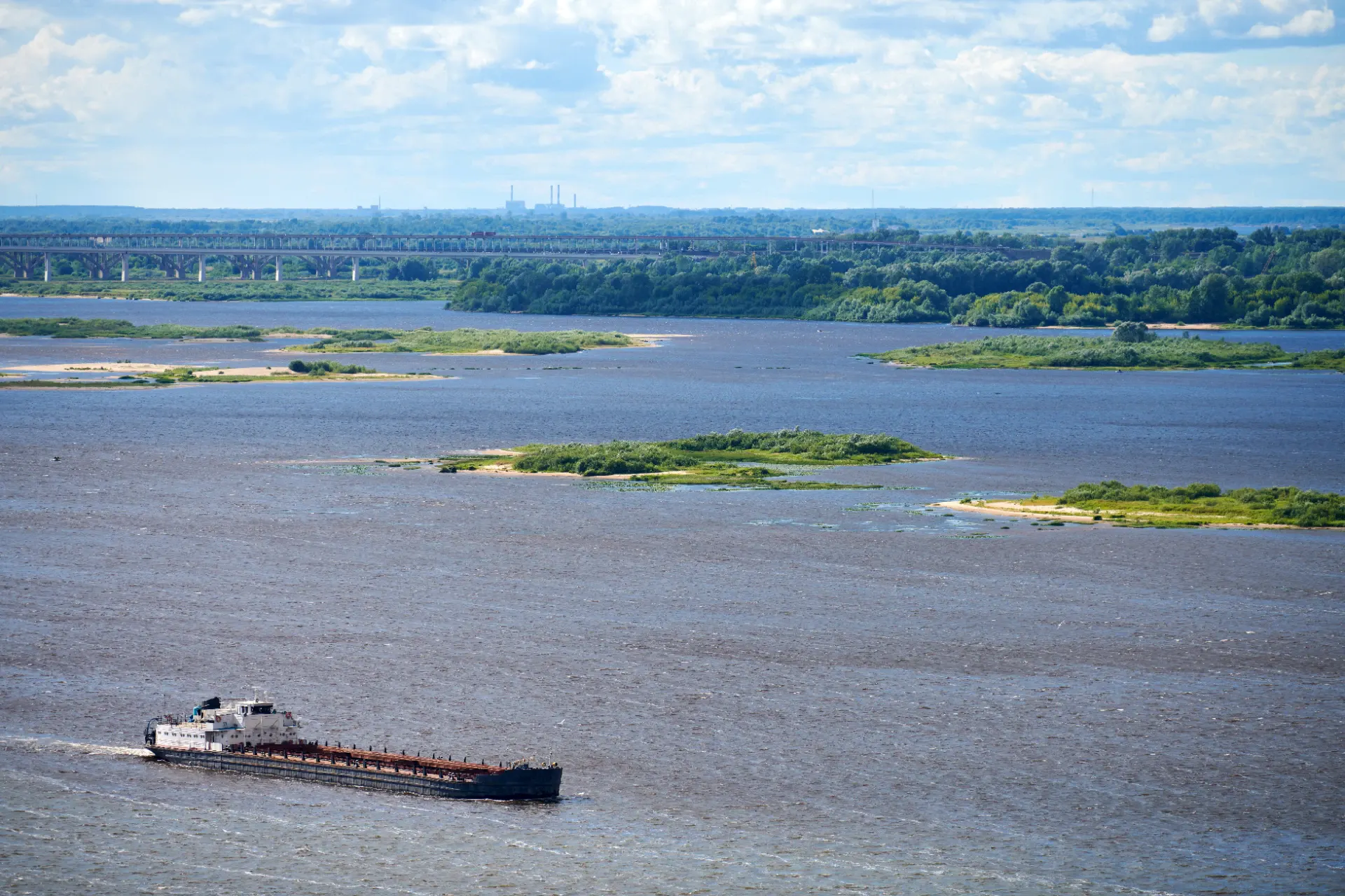 A cargo barge under way on a river towards port
