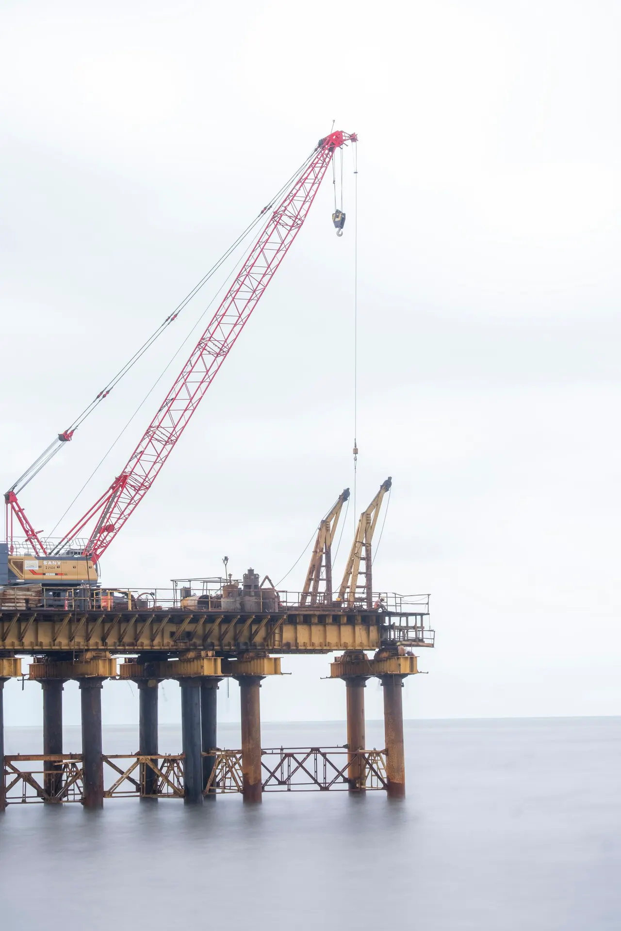 Crane on an offshore platform over calm water