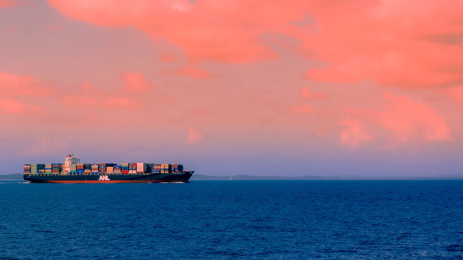 Cargo ship at sea under a cloudy sky