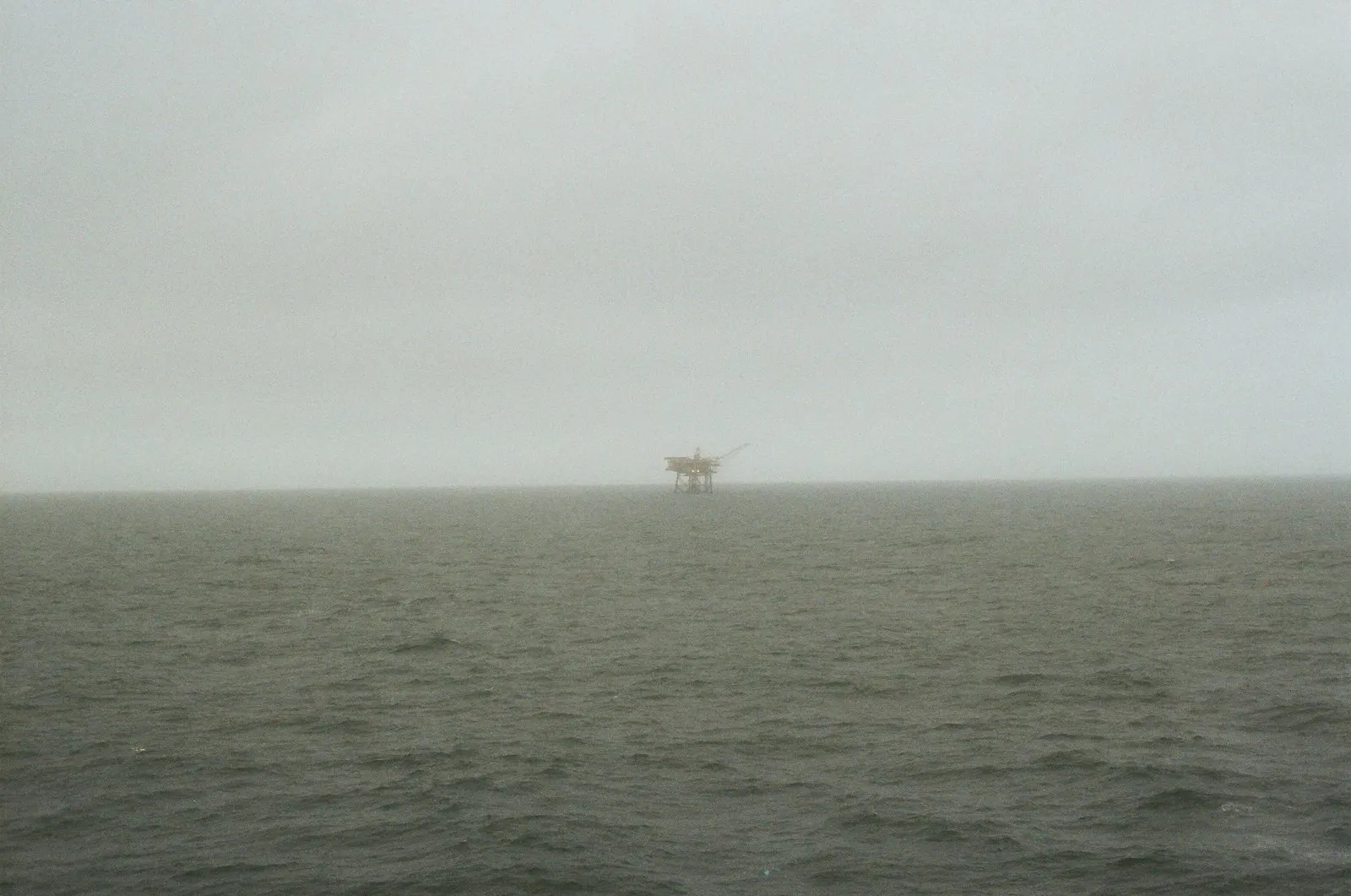 Offshore drilling rig at sea in foggy conditions
