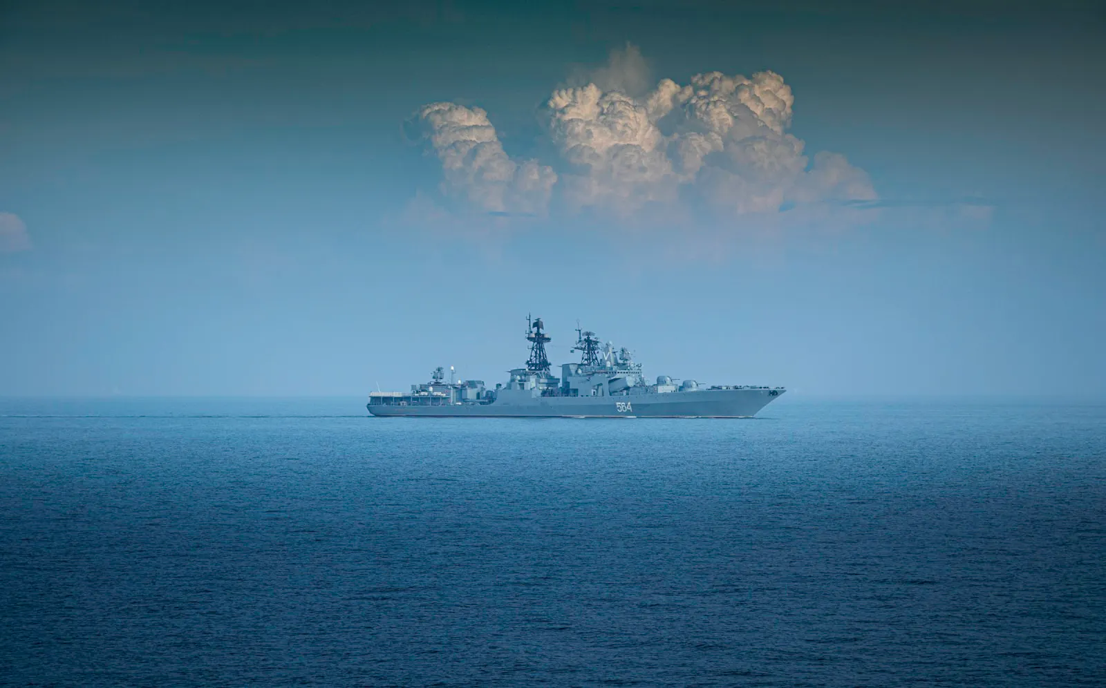 A grey naval frigate underway in open water