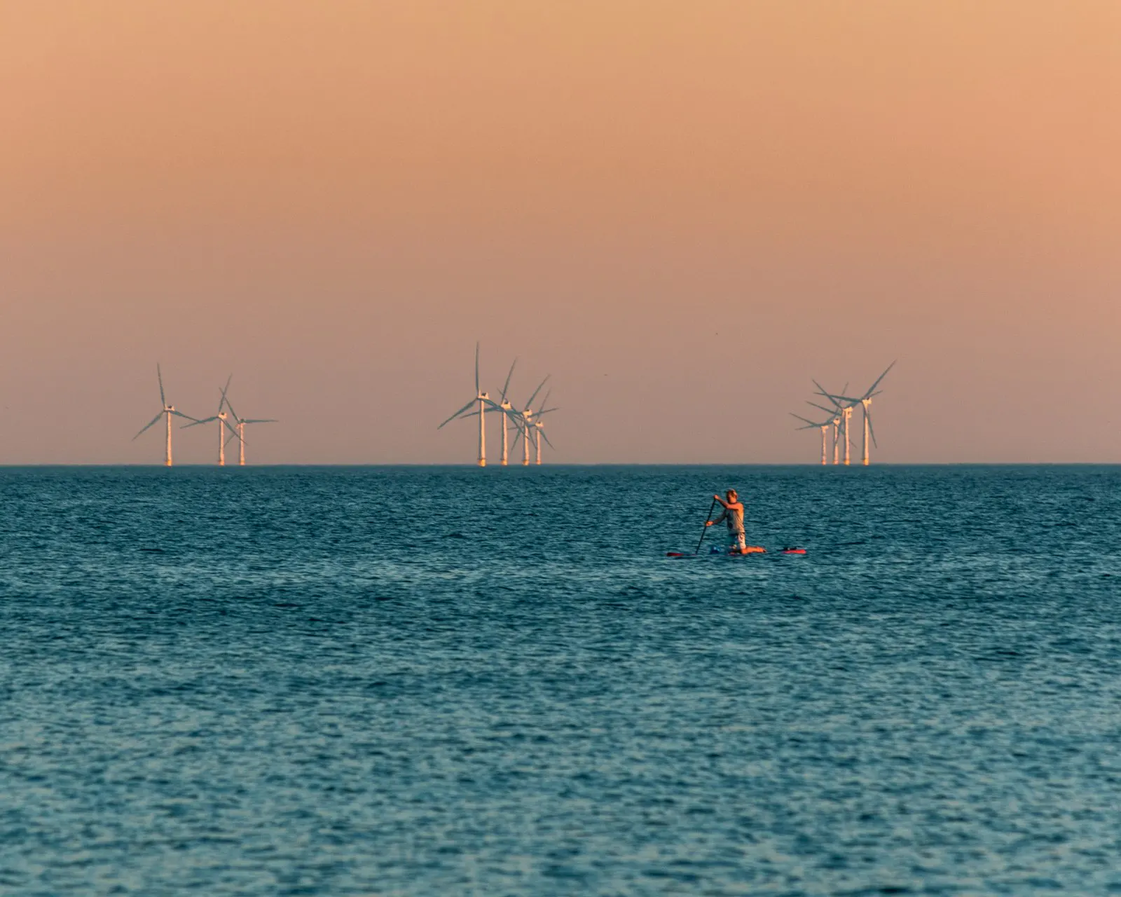 A floating wind turbine foundation under construction at a coastal yard
